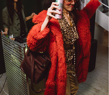Person dancing in red fur coat at party