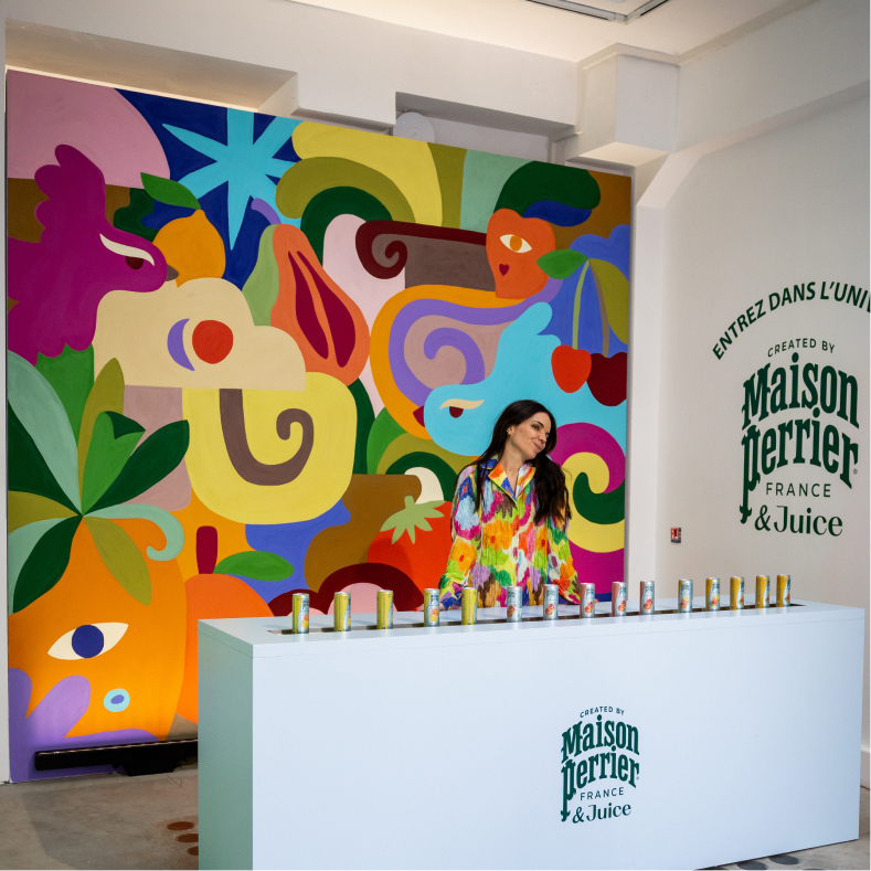 Colorful Maison Perrier juice display with mural background