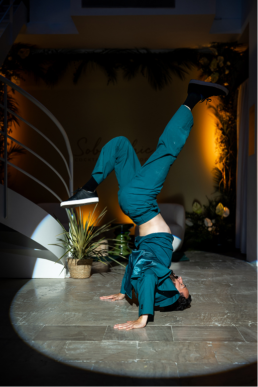 Dancer performing headstand in spotlight indoors